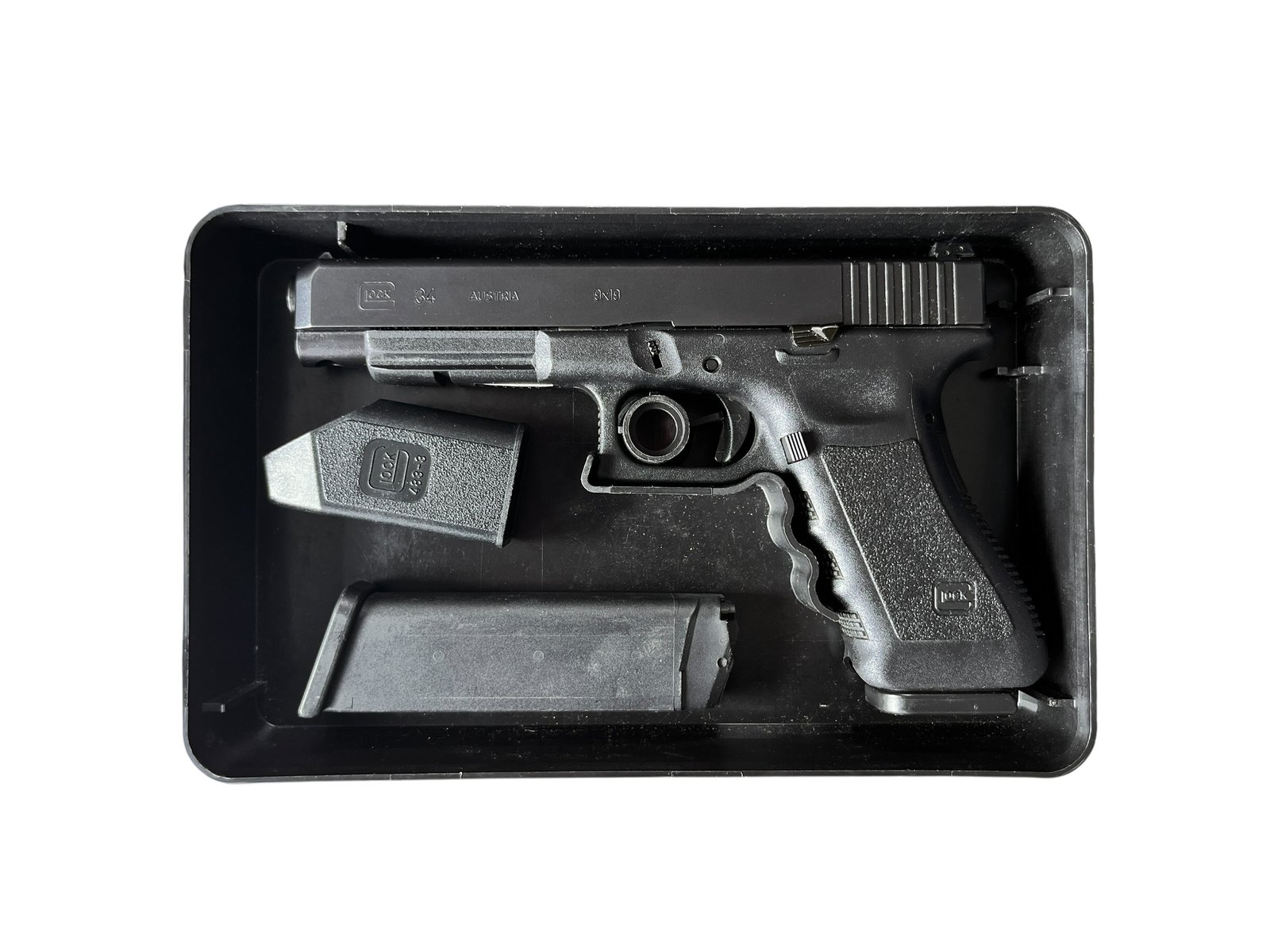 Sportowy pistolet samopowtarzalny Glock 34 Gen 3 w kalibrze 9x19 mm z dwoma magazynkami i szybko ładowarką.
